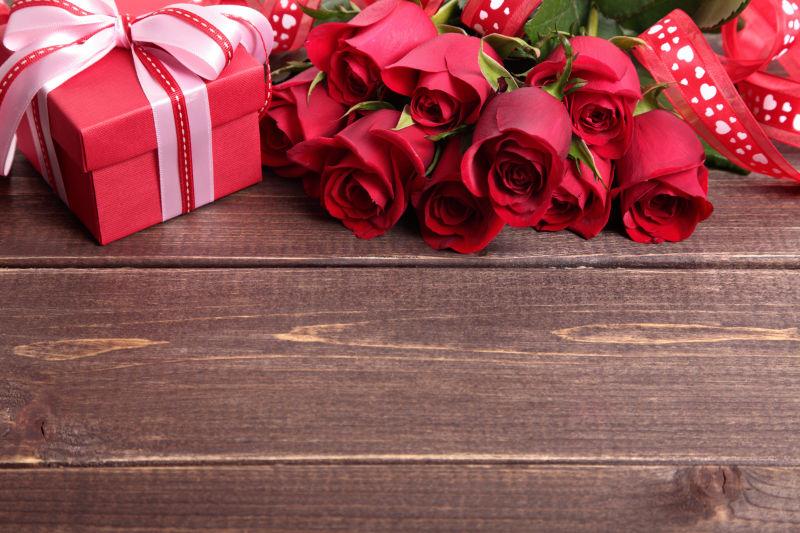 木制背景上的情人节礼物盒和红玫瑰