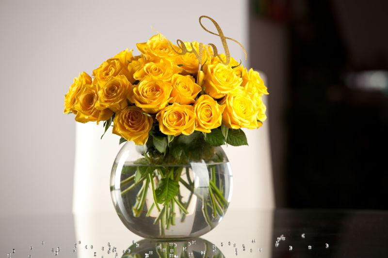 圆形花瓶里放着黄色玫瑰花