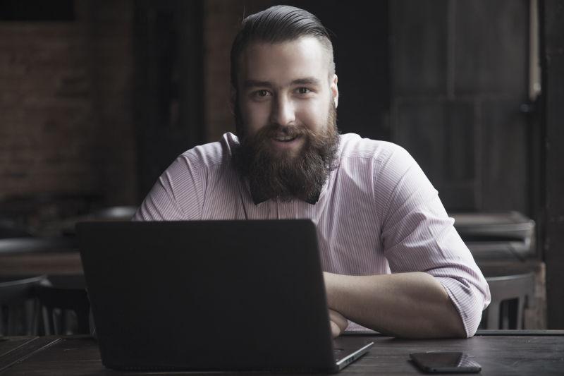有胡子的男子用笔记本电脑