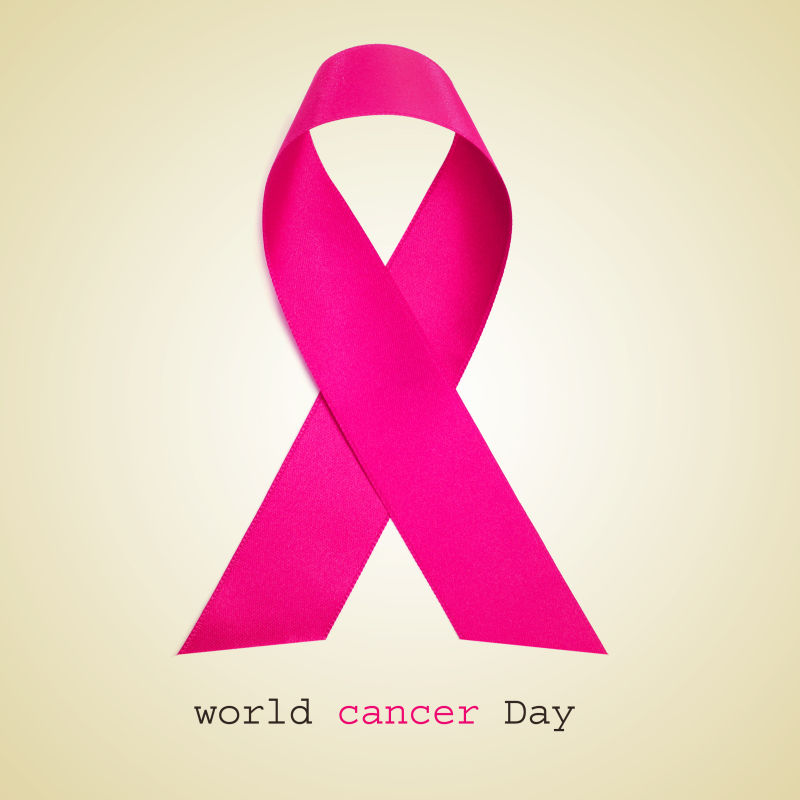 《世界癌症日》和米色背景下的粉红丝带