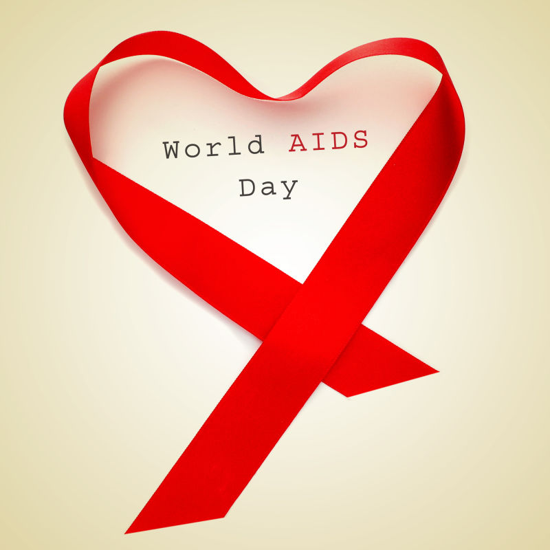 一个红色的丝带构成一个心脏和文本世界艾滋病日米色背景