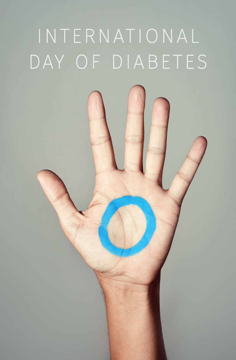 一个年轻人手掌上的蓝色圆圈和国际糖尿病日