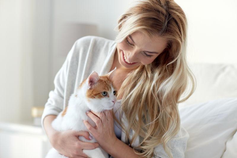 金发美女坐在床上抱着小猫