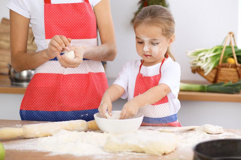 母亲和孩子的女儿烹调节日馅饼或饼干