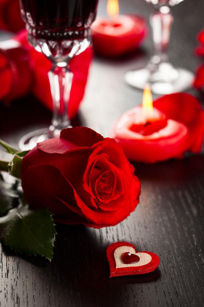 黑色桌面上的红玫瑰和蜡烛