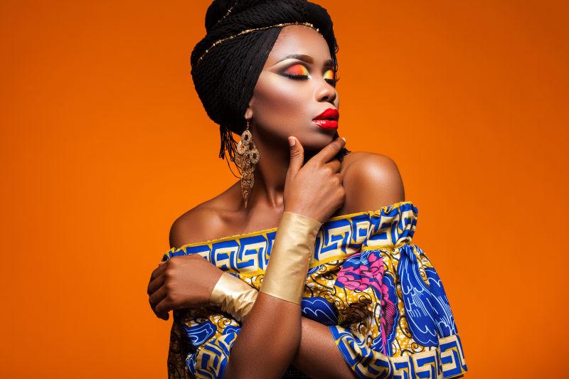 橙色背景下的拥有浓浓的妆容的非洲女人