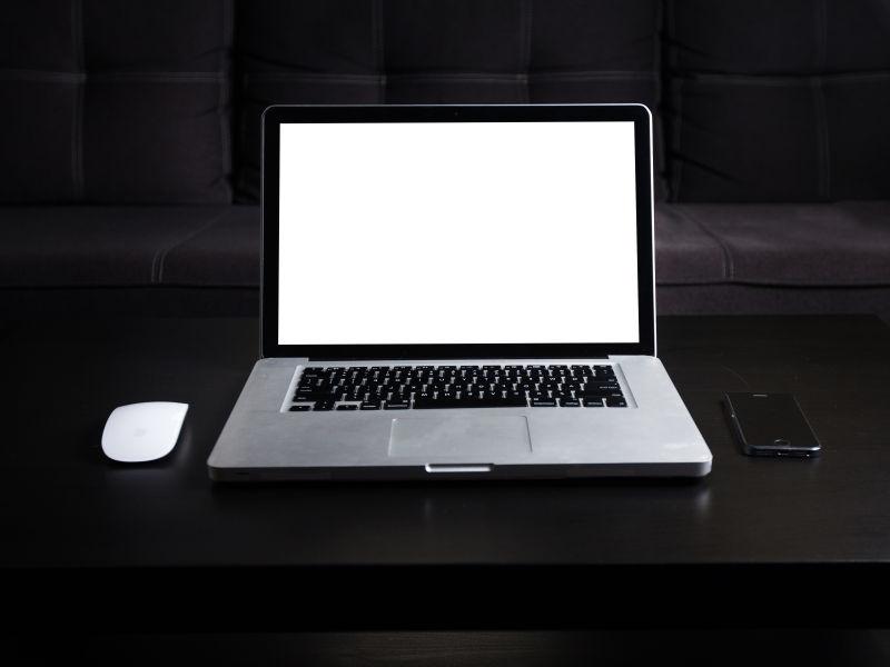 暗木桌上空白屏幕的笔记本电脑