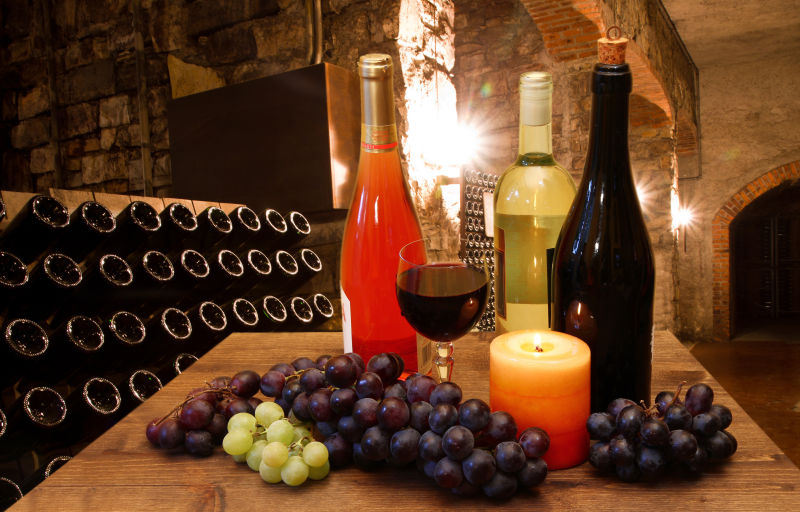 酒窖木桌上的葡萄葡萄酒和蜡烛
