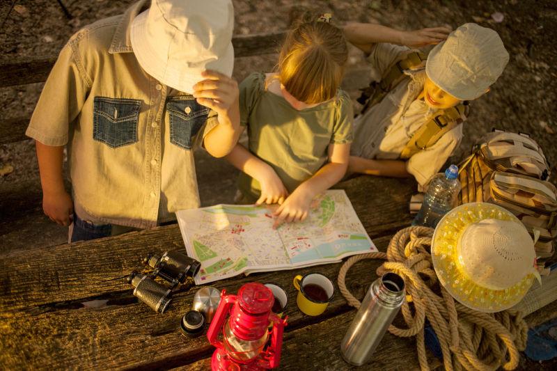 夕阳下研究地图的探险的孩子们
