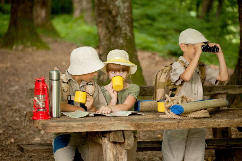 野外探险坐在桌子旁喝水的孩子们