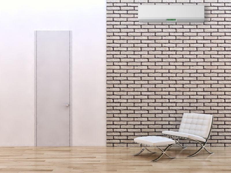砖墙背景上的空调和木地板上的椅子