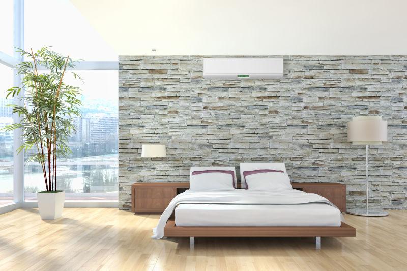 青色砖墙背景上的空调和木地板上的舒适的床