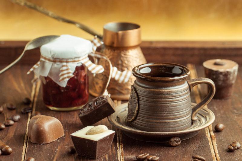 木桌上的巧克力糖和咖啡杯