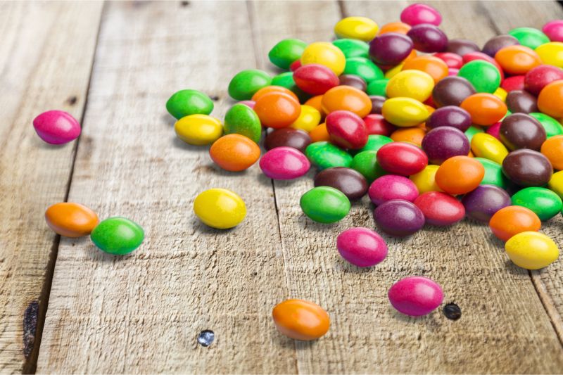 洒落在木质板上的彩色糖果