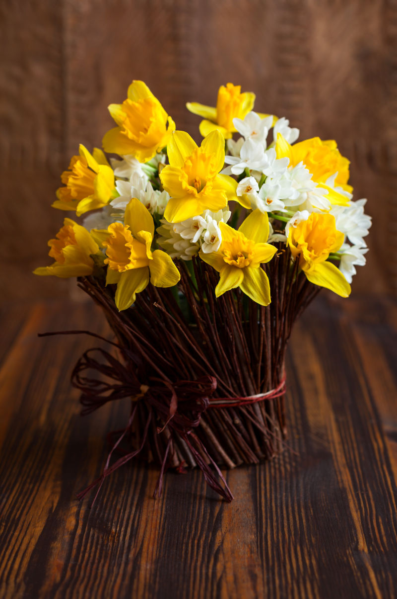 木桌上的一束黄色和白色的水仙花