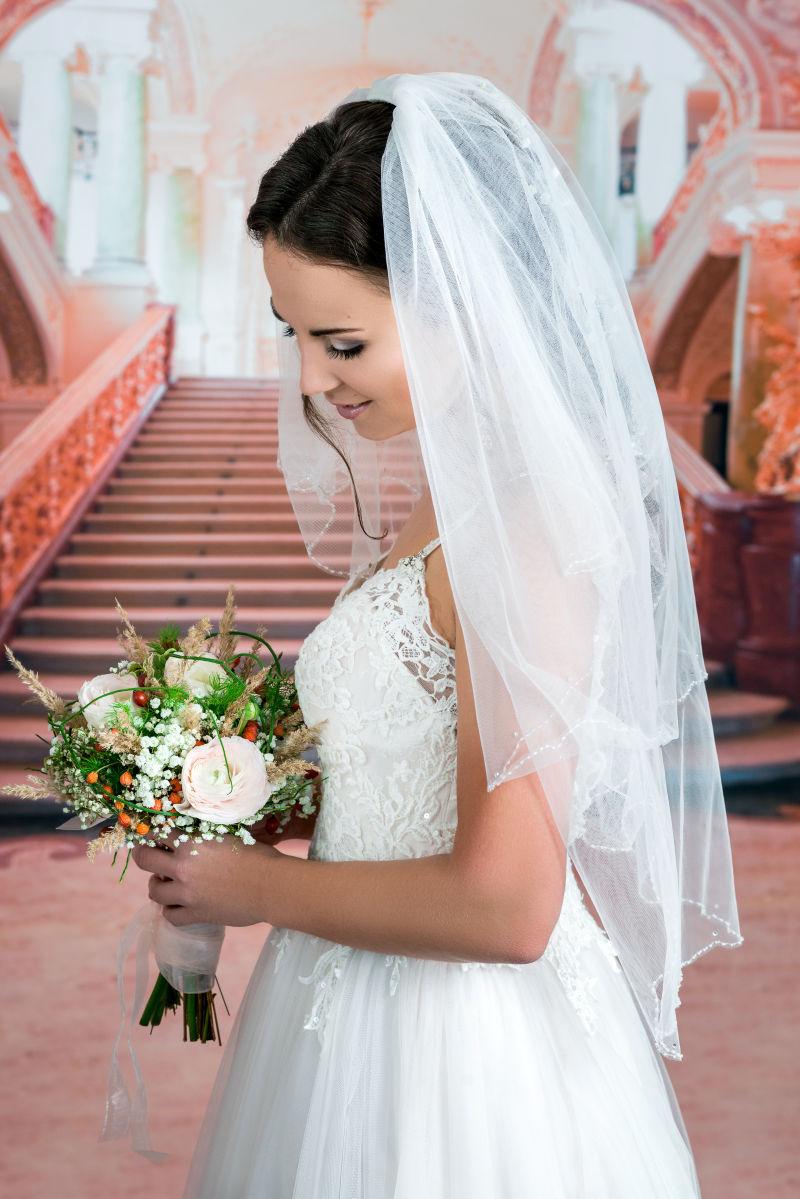 带着面纱的新娘拿着一束手捧花