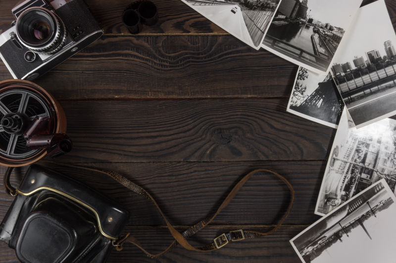 旧木桌上的复古相机和黑白相片