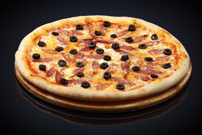 黑色背景下的香肠披萨