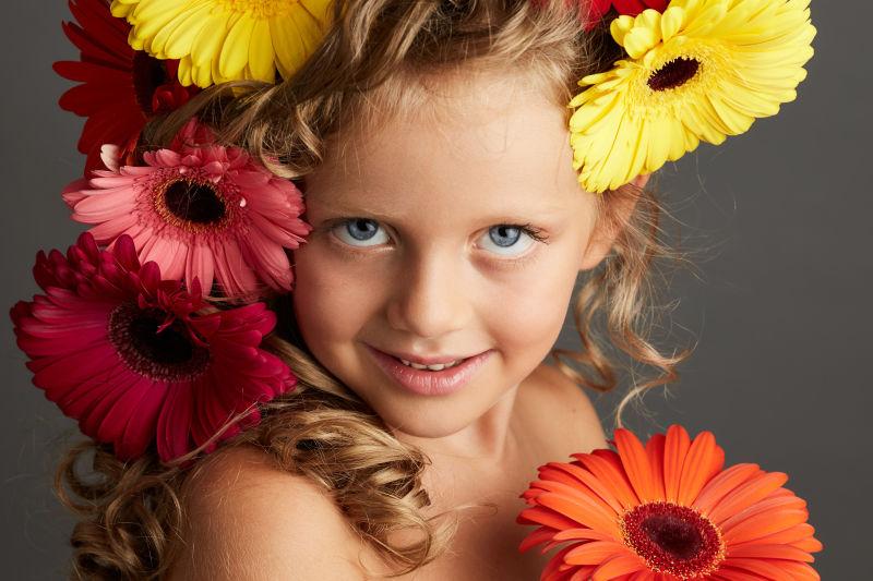 灰色背景下的gerbera daisy小女孩的美丽画像