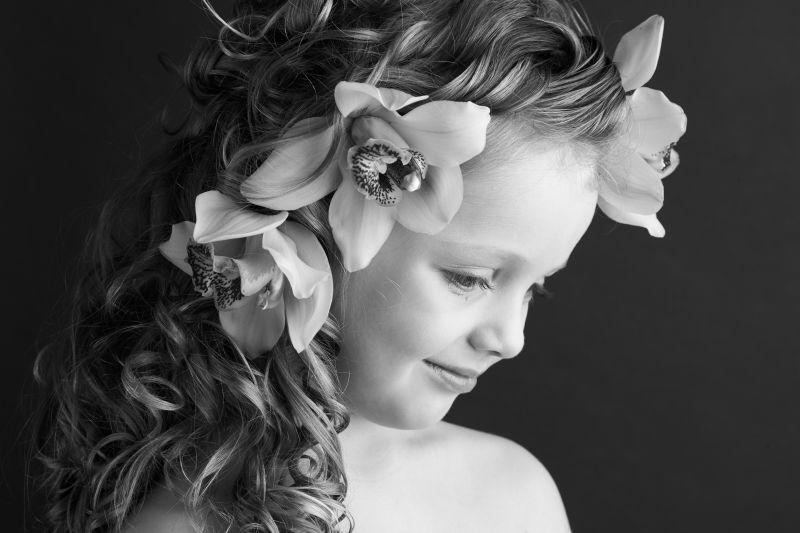 一个美丽的小女孩在她的头发上用兰花的黑白摄影
