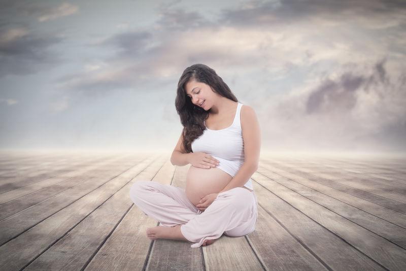 坐在木板上的怀孕的孕妇