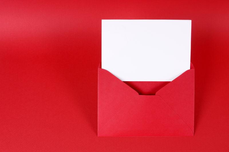 红色桌上红色信封里的白色卡片