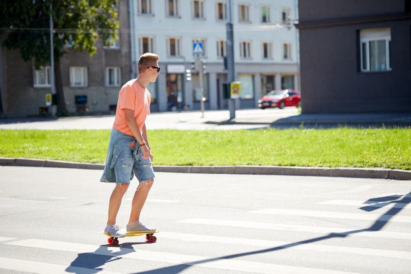 在城市街道玩滑板的男孩