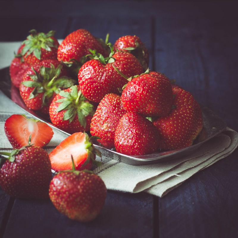 黑木桌上一盘新鲜的草莓