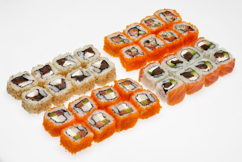 把不同类型寿司放在白色背景的盘子上