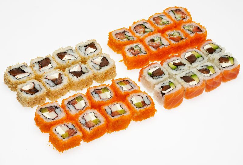不同类型的卷寿司在白色背景上的盘子上