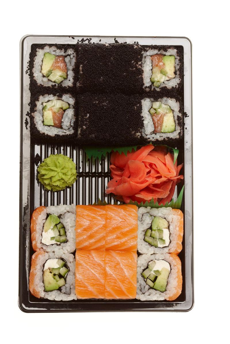 不同类型的卷寿司在白色背景上的盘子上隔开