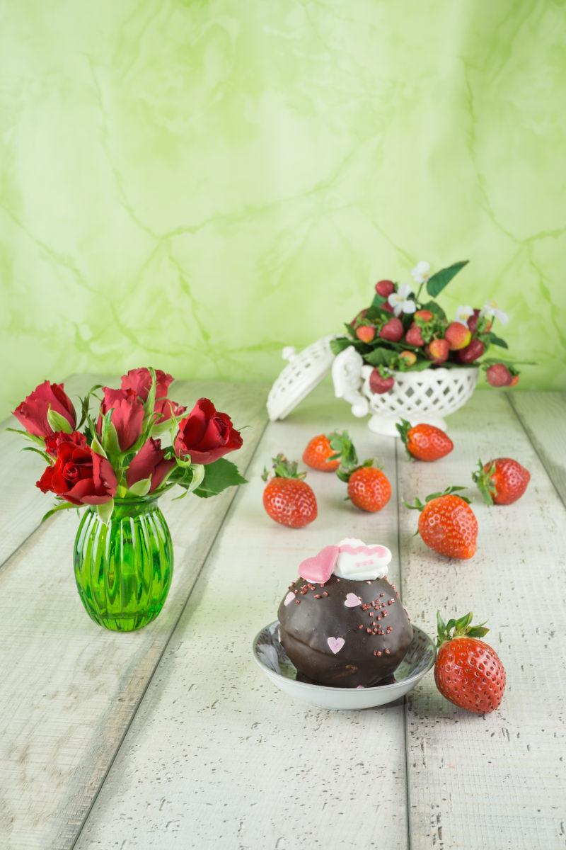 木制桌面上的巧克力甜点草莓和鲜花装饰