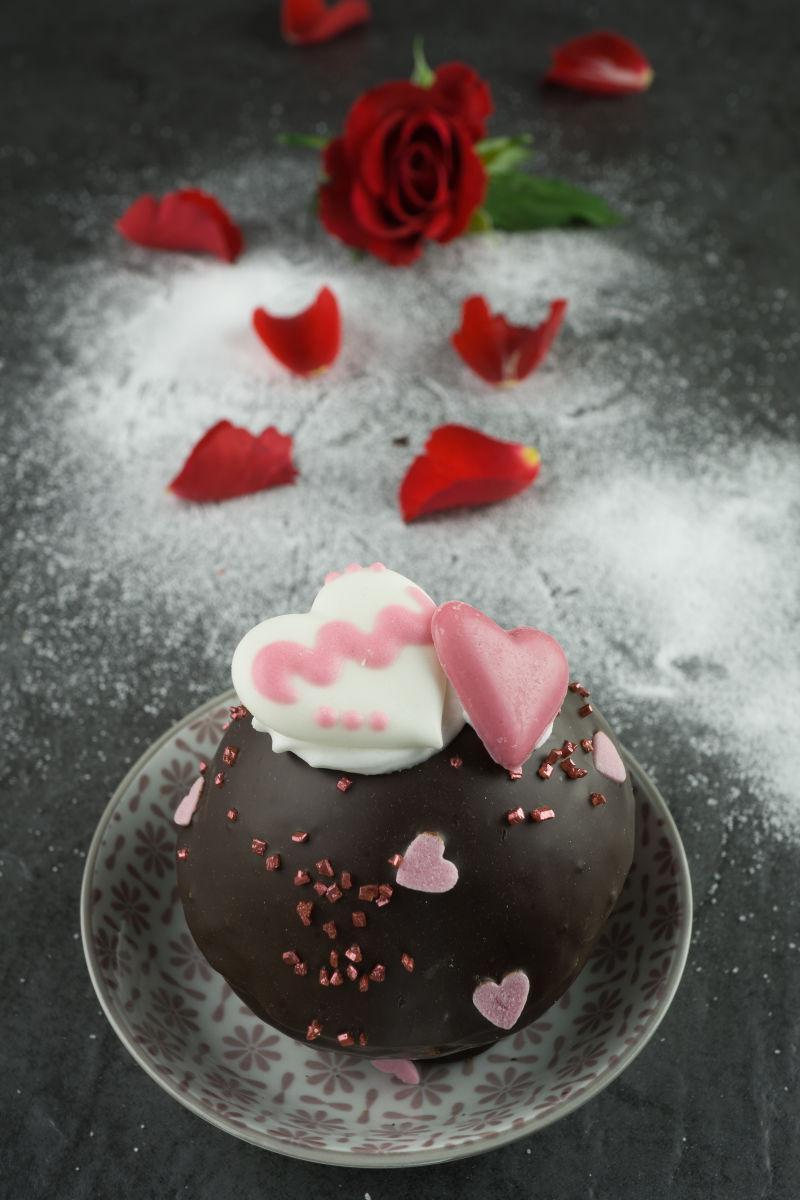 红玫瑰花瓣背景中的巧克力甜点