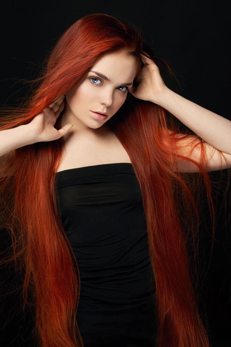 黑色背景下性感美丽的红发女孩