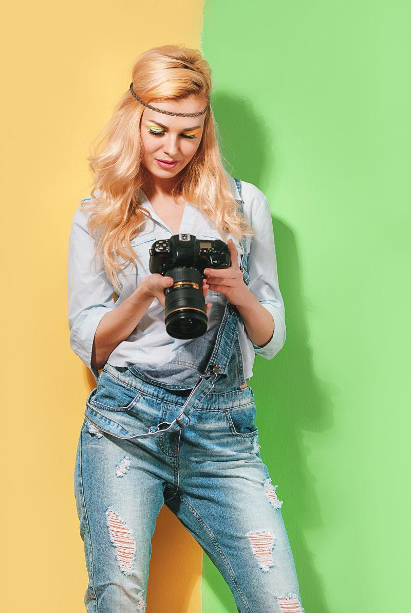 彩色条纹前看着自己拍照成果的女摄影师