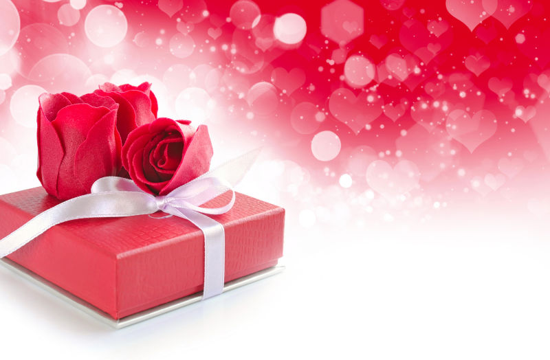 心形浪漫背景中的礼物和红玫瑰