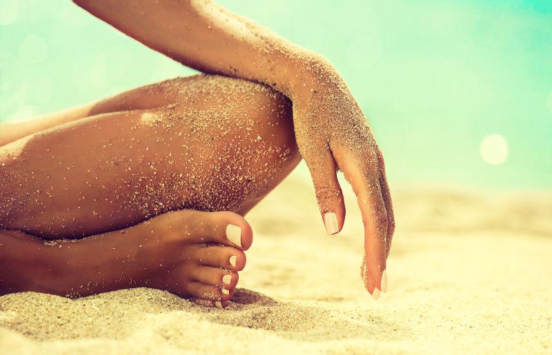 在沙滩上休息的女子身上带有沙子