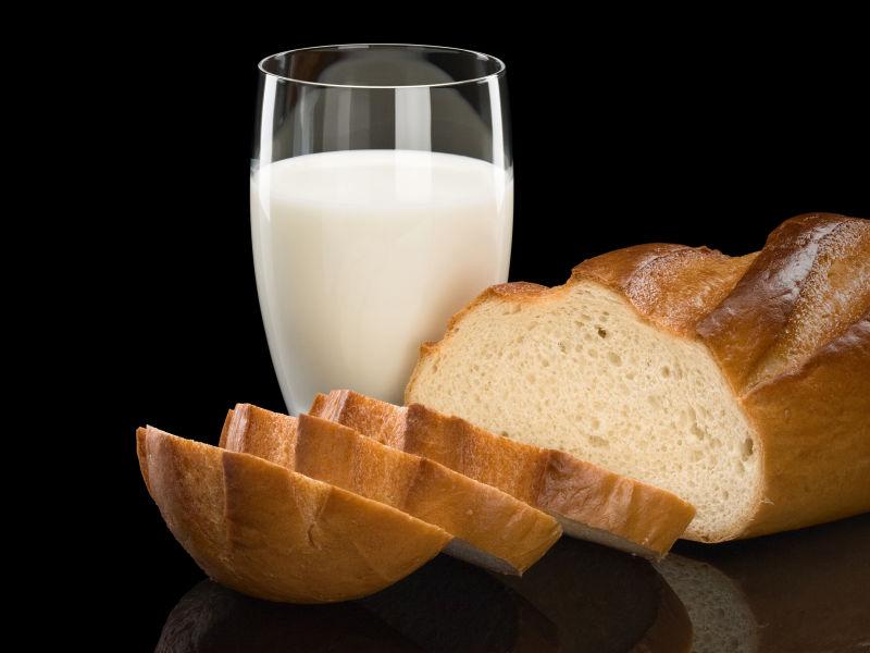 把长面包切成片和杯子里的牛奶