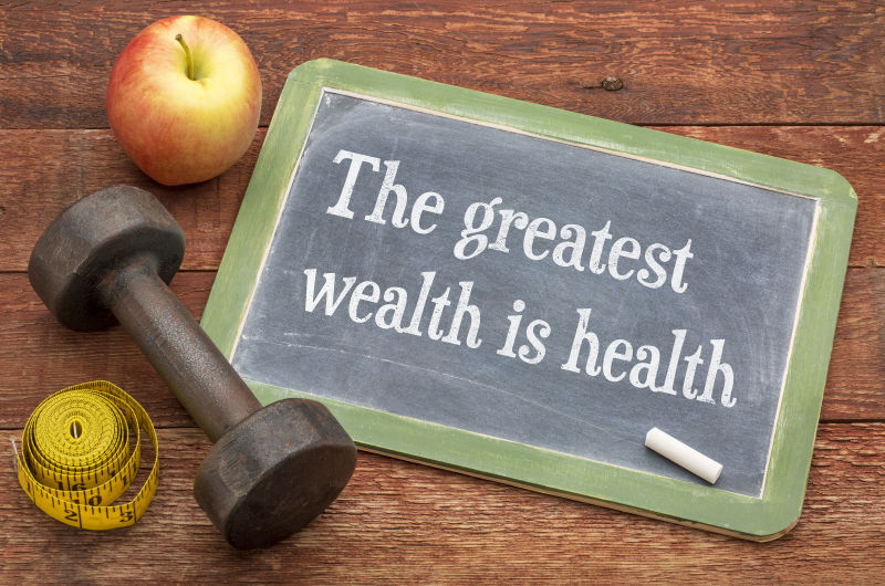 褐色木桌上的写着健康生活方式的黑板和哑铃苹果等