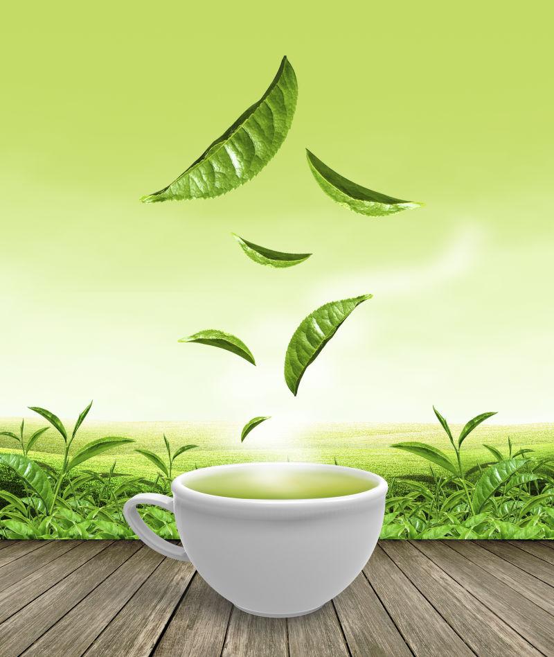 冒着热气的绿茶杯子上面的绿叶