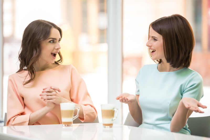 两个女爱坐一起聊天喝咖啡