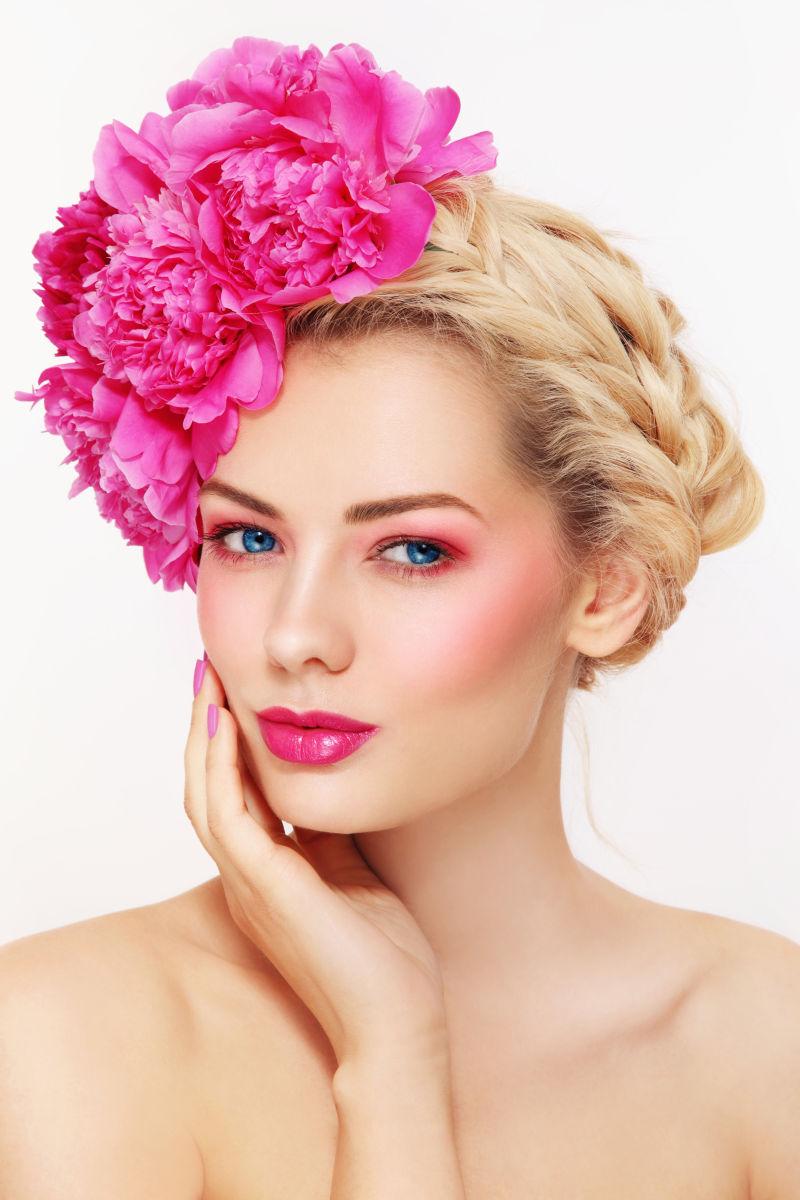 美丽的金发女人头戴粉红色牡丹花