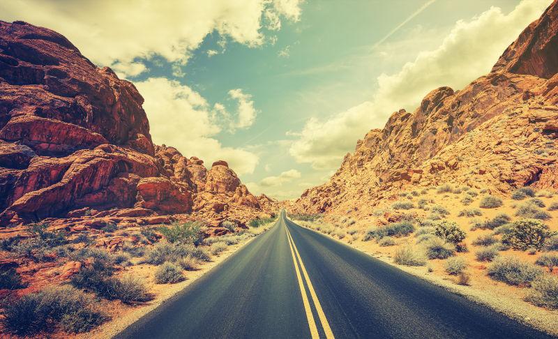 蓝天白云背景下的复古风格的沙漠公路