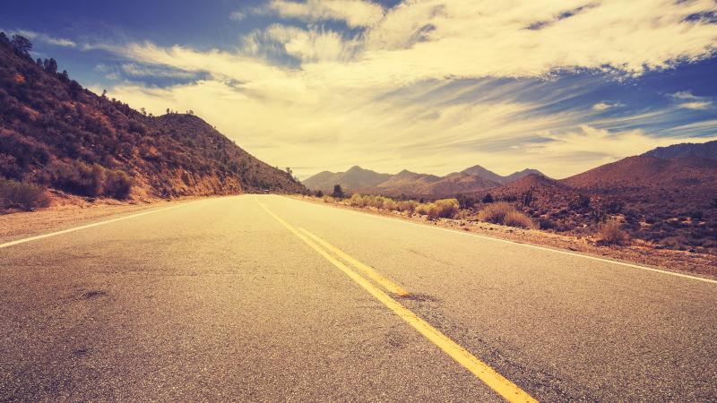 蓝天白云下的旧式复古风格沙漠公路