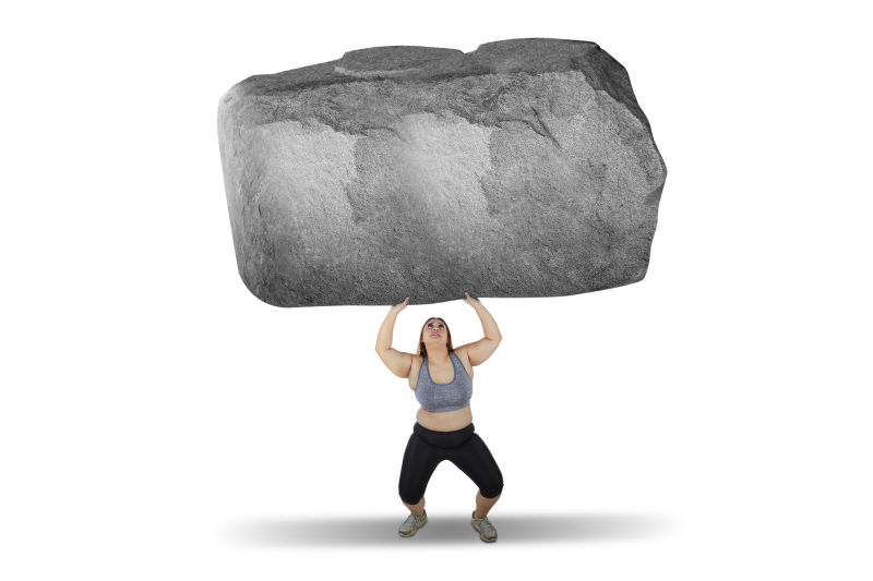 白色背景下胖女人举起大石头