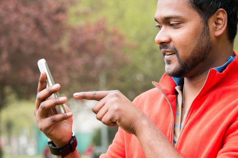 印度男子在公园里使用手机