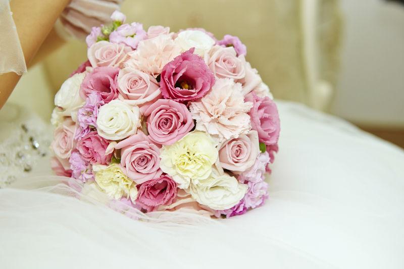 新娘裙摆上的粉红色的手捧花