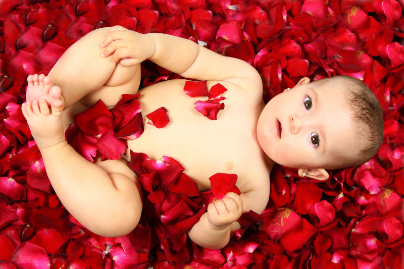躺在玫瑰花瓣上的可爱婴儿