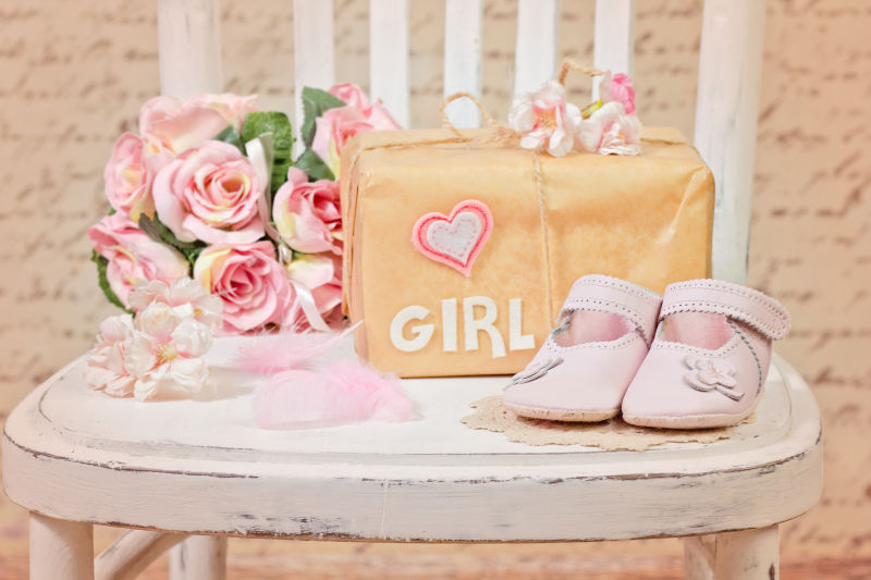 桌子上婴儿的粉色鞋子和包包