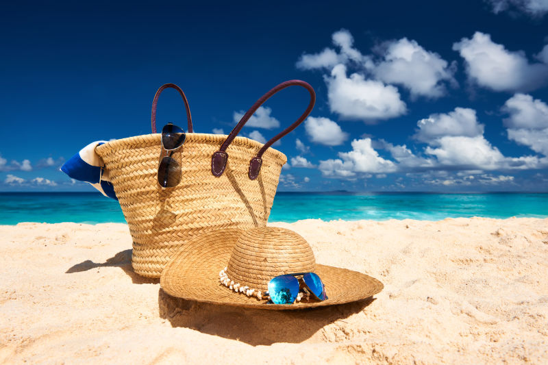 沙滩上的遮阳帽和旅游包